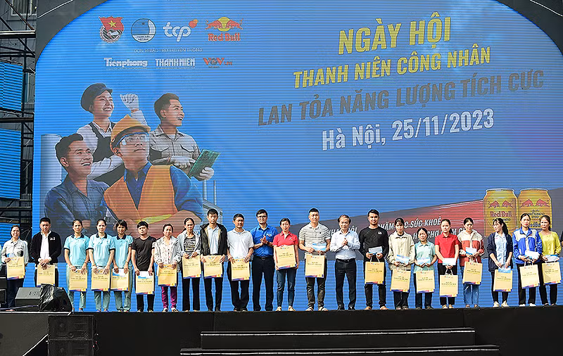 Các đồng chí Phạm Tất Thắng, Ủy viên Trung ương Đảng, Phó Trưởng Ban Thường trực Ban Dân vận Trung ương; Bùi Quang Huy, Ủy viên dự khuyết Trung ương Đảng, Bí thư thứ nhất Trung ương Đoàn (thứ 9 và 12 từ phải sang) trao quà tặng thanh niên công nhân.