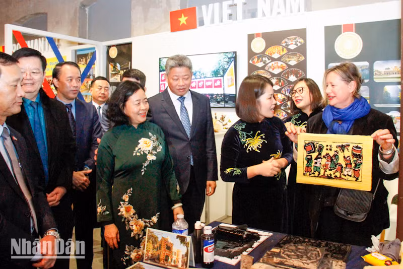 Bà Karine Yris, Giám đốc phụ trách phát triển thương mại và bảo trợ văn hóa - nghệ thuật của Trung tâm 104, được trải nghiệm làm tranh Đông Hồ. (Ảnh: MINH DUY)