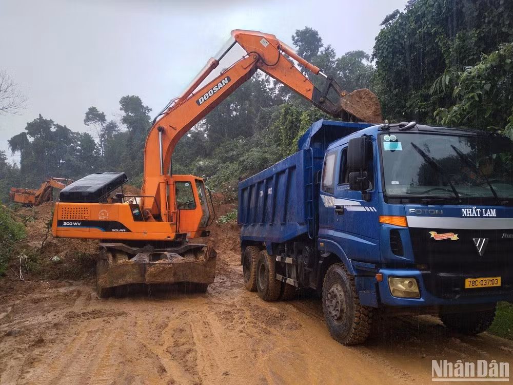 Công ty CP Quản lý và xây dựng đường bộ Phú Yên khẩn trương đưa máy móc hốt dọn, khắc phục sự cố sạt lở tuyến quốc lộ 19C. 