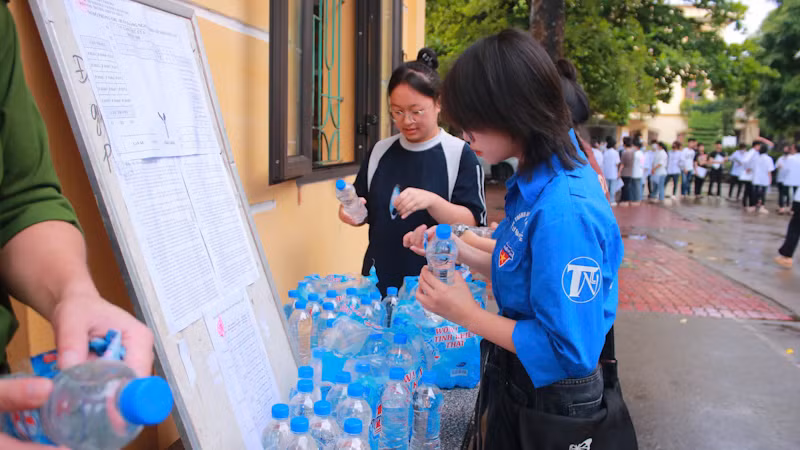 Đội thanh niên tình nguyện chuẩn bị nước uống tặng cho thí sinh. (Ảnh: QUANG HUY)