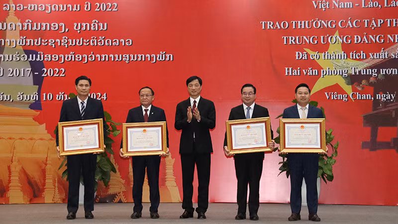 Đồng chí Nguyễn Duy Ngọc trao tặng Huân, Huy chương cho các tập thể, cá nhân của Văn phòng Trung ương Đảng Nhân dân Cách mạng Lào. Ảnh: Hải Tiến