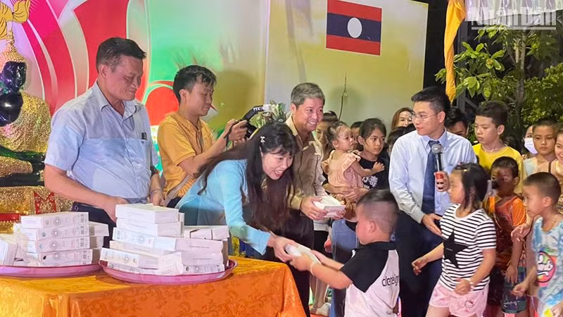 Ban tổ chức trao quà cho các cháu thiếu nhi là con em cộng đồng người Việt Nam tại Lào. (Ảnh: HẢI TIẾN)