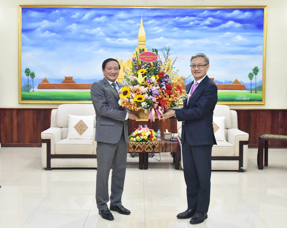 Đại sứ Nguyễn Bá Hùng chúc mừng Trưởng Ban Đối ngoại Trung ương Đảng Nhân dân Cách mạng Lào Thongsavanh Phomvihane. (Ảnh: Trịnh Dũng)