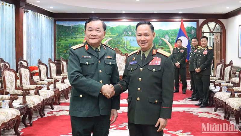 Thượng tướng Hoàng Xuân Chiến chào Bộ trưởng Quốc phòng Lào Khamlieng Outhakaysone. (Ảnh: TRỊNH DŨNG)
