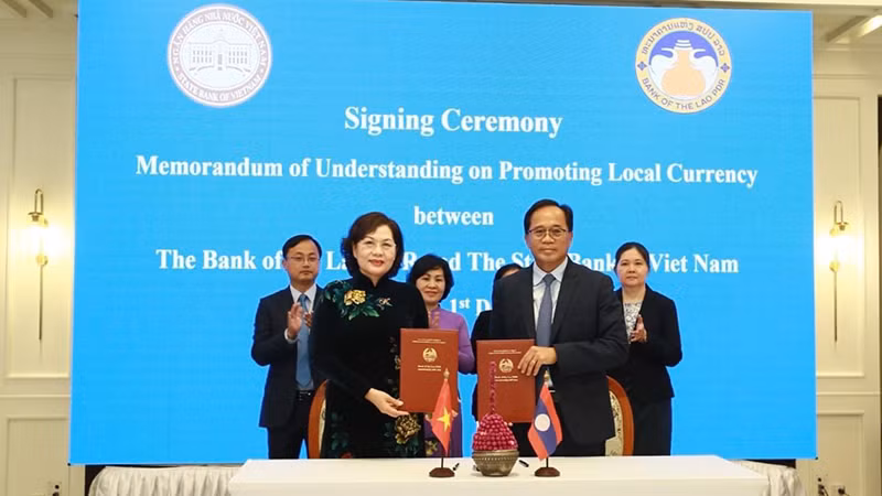 Bà Nguyễn Thị Hồng, Thống đốc Ngân hàng Nhà nước Việt Nam và ông Buonluea Sinxayvoravong, Thống đốc Ngân hàng nhà nước Lào tại lễ ký kết. Ảnh: Báo Pasaxon