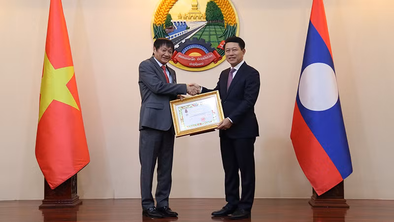 Phó Thủ tướng, Bộ trưởng Ngoại giao Lào trao Huân chương Itxala hạng Ba tặng Đại sứ Nguyễn Bá Hùng. (Ảnh: HẢI TIẾN)