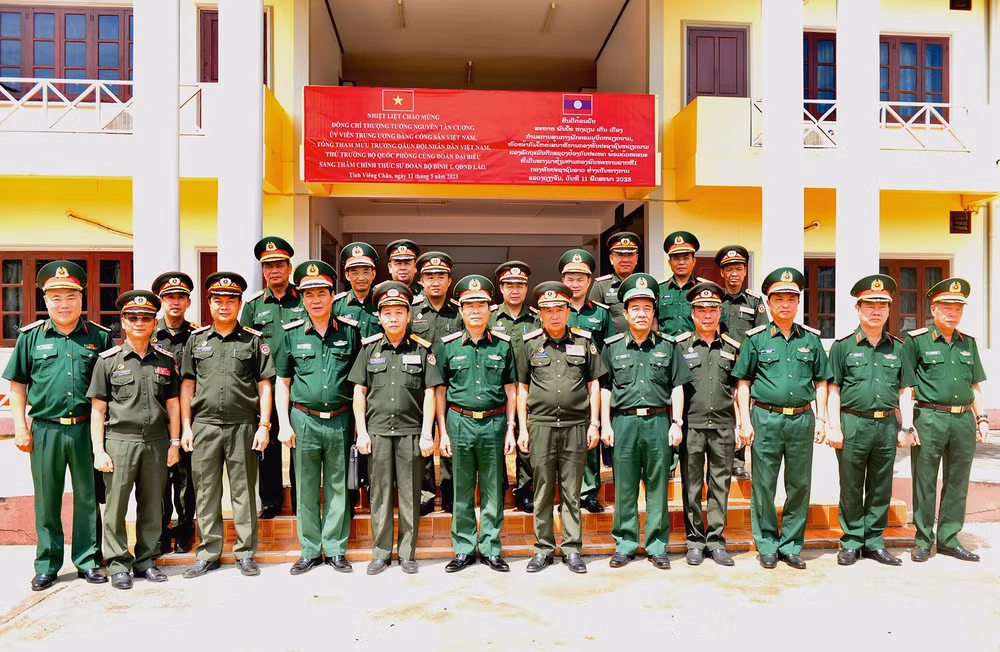 Thượng tướng Nguyễn Tân Cương và Đoàn đại biểu chụp ảnh lưu niệm với lãnh đạo Sư đoàn Bộ binh 1, Quân đội nhân dân Lào. (Ảnh: Trịnh Dũng)