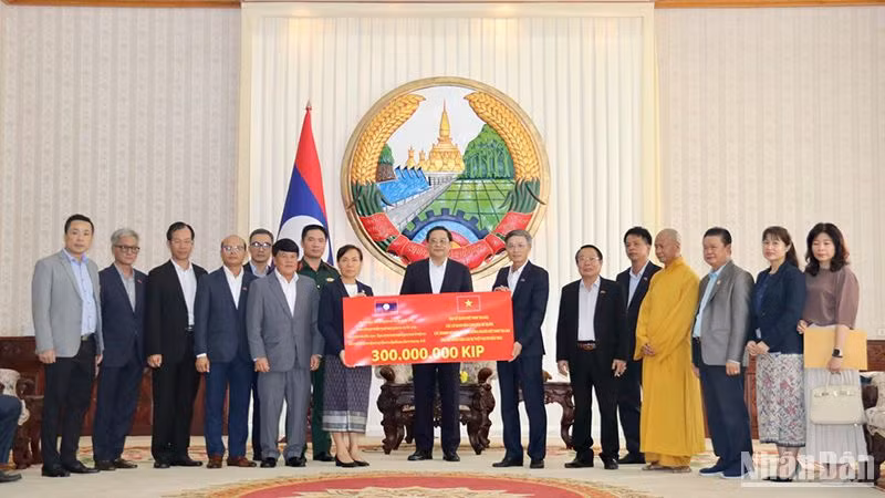 Cộng đồng người Việt Nam ủng hộ người dân Lào 300 triệu kíp khắc phục hậu quả thiên tai. Ảnh: Hải Tiến