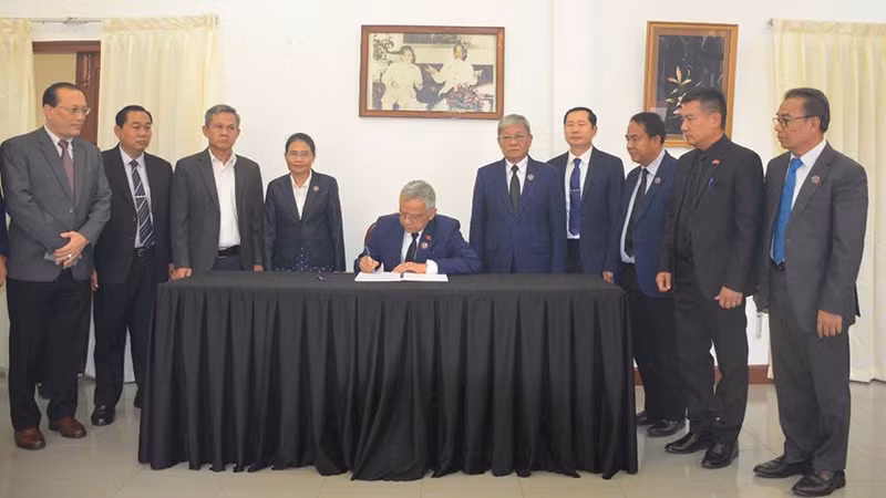 Phó Chủ tịch Quốc hội Lào Sommad Pholsena ghi sổ tang. (Ảnh: Cộng tác viên)