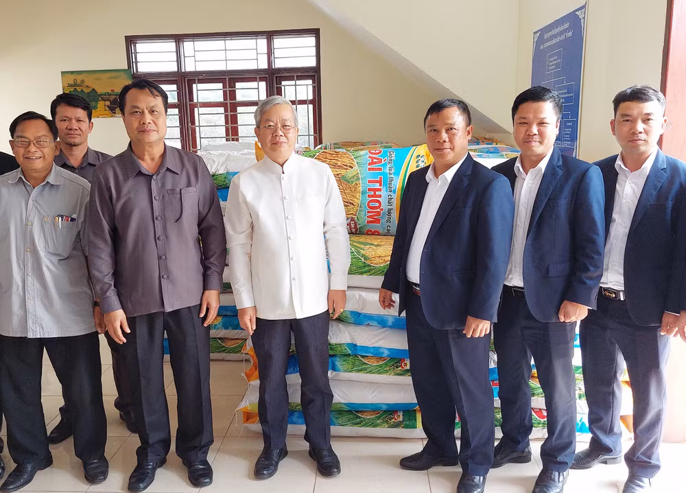 Đại diện lãnh đạo Công ty 705/Quân khu 2 bàn giao 10 tấn thóc giống cho chính quyền tỉnh Oudomxay (Lào). (Ảnh: Hải Tiến)