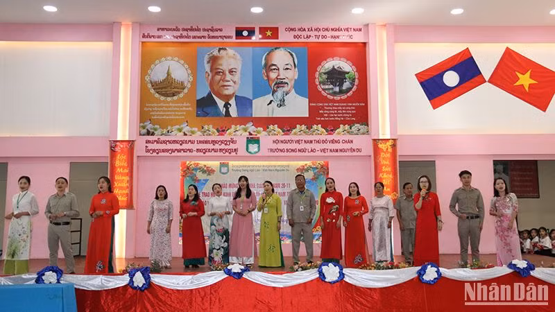 Tập thể giáo viên Trường Song ngữ Lào-Việt Nam Nguyễn Du biểu diễn ca khúc “Bài ca người giáo viên nhân dân”. (Ảnh: Hải Tiến)