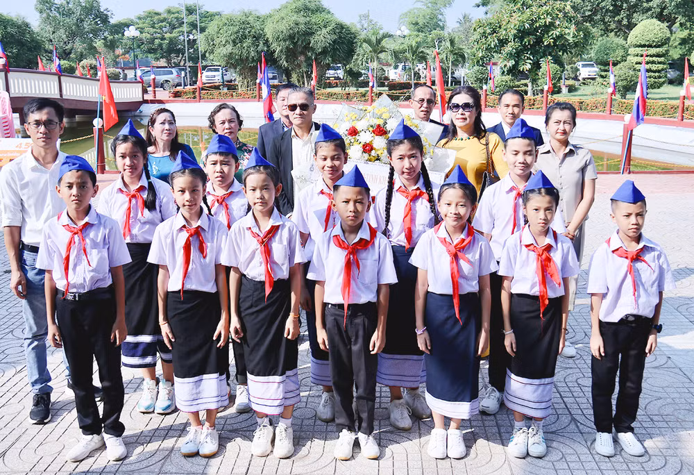 Hội người Việt Nam tỉnh Khammuon và các thầy cô giáo, các em học sinh Trường Thống Nhất Việt Triều-Thà Khẹc dâng hoa bày tỏ lòng thành kính. (ẢNH: TRINH DŨNG)