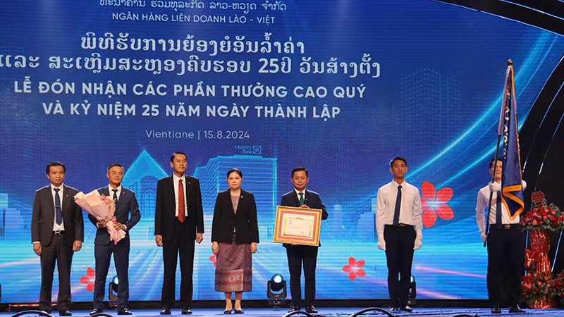 Ngân hàng liên doanh Lào-Việt đón nhận Huân chương Lao động hạng Nhất của Lào. (Ảnh: Hải Tiến)