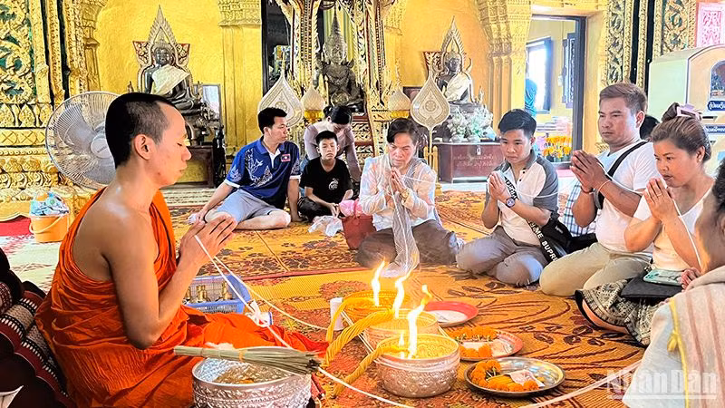 Người dân Lào tham gia nghi lễ buộc chỉ cổ tay đón năm mới 2567 theo Phật lịch của Lào. Ảnh: Trịnh Dũng