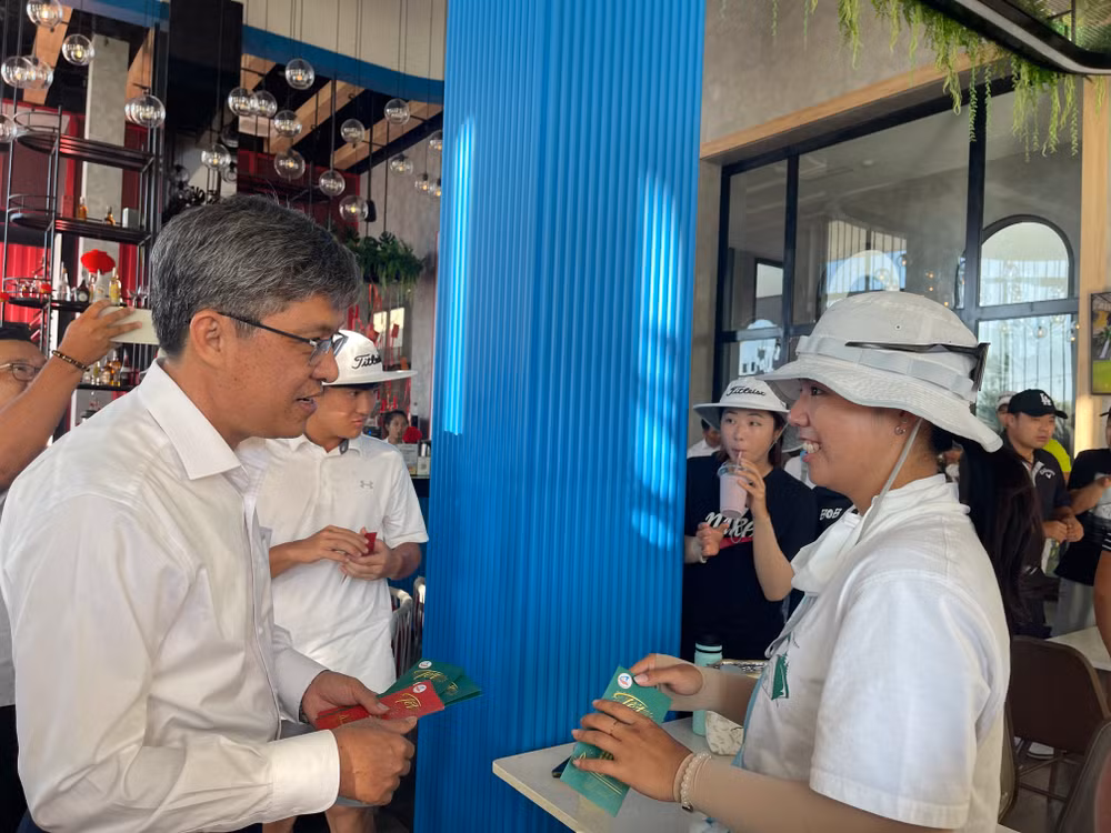 Ông Nguyễn Minh, Phó Chủ tịch Uỷ ban nhân dân tỉnh Bình Thuận lì xì cho du khách lưu trú tại resort K-Town vào mùng 1 Tết Nguyên đán Giáp Thìn