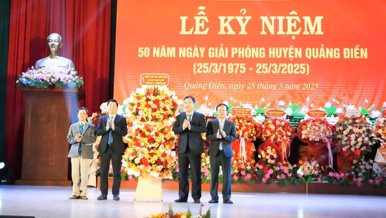 Đồng chí Phó Bí thư Thường trực Thành ủy Huế Phạm Đức Tiến (thứ 2 bên phải) tặng hoa chúc mừng Đảng bộ, chính quyền, quân và dân Quảng Điền tại lễ kỷ niệm.