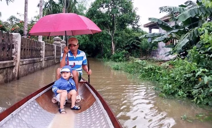 Nhiều tuyến đường ngập sâu, người dân ở vùng thấp trũng Quảng Điền, Hương Trà (tỉnh Thừa Thiên Huế) phải di chuyển bằng thuyền.