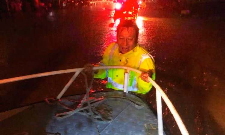 Cán bộ Cảnh sát giao thông Công an thành phố Huế dầm mình trong nước lũ để đẩy ca nô tiếp cận