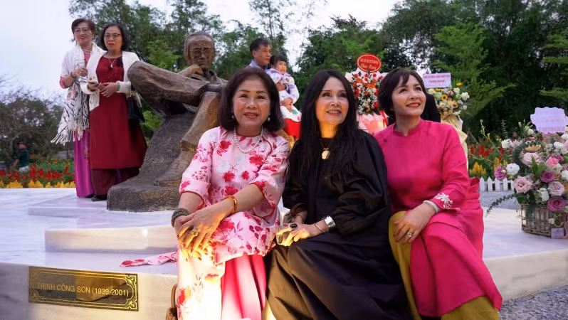 Các nghệ sỹ, bạn bè, thân hữu gia đình cố nhạc sĩ Trịnh Công Sơn chụp ảnh lưu niệm bên tượng Trịnh Công Sơn.