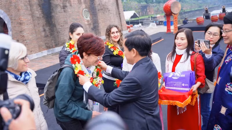 Chủ tịch Ủy ban nhân dân thành phố Huế Nguyễn Văn Phương tặng hoa, quà cho các du khách quốc tế tham quan Di sản Huế ngày đầu năm mới.