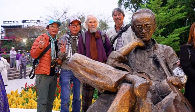 Các nghệ sỹ, bạn bè, thân hữu gia đình cố nhạc sĩ Trịnh Công Sơn chụp ảnh lưu niệm bên tượng Trịnh Công Sơn.