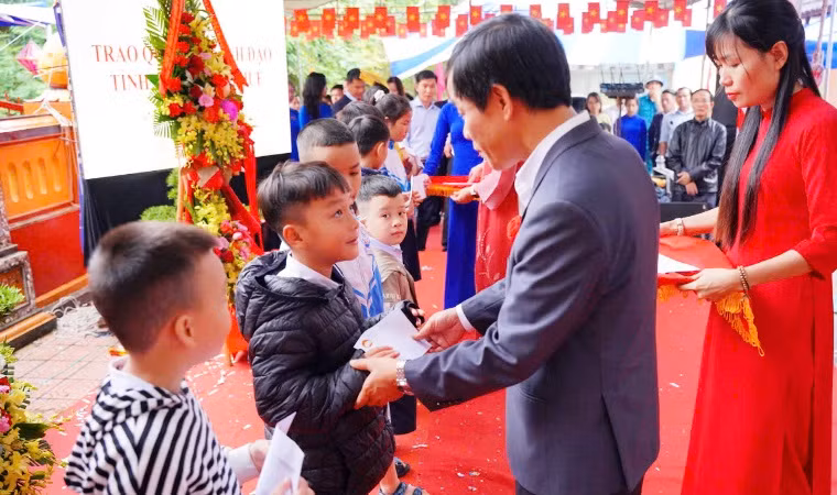 Chủ tịch Ủy ban nhân dân tỉnh Nguyễn Văn Phương trao quà tặng các em học sinh nghèo.