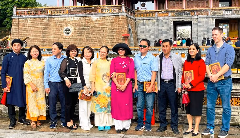 Du khách thích thú chụp hình cùng những cuốn lịch được tặng tại Lễ Ban Sóc.