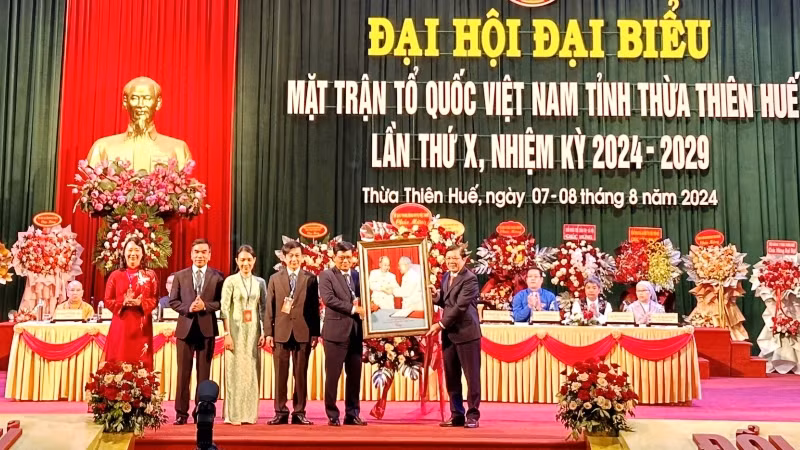 Phó Chủ tịch Ủy ban Trung ương Mặt trận Tổ quốc Việt Nam Nguyễn Hữu Dũng trao bức tranh Bác Hồ, Bác Tôn của Ủy ban Trung ương Mặt trận Tổ quốc Việt Nam tặng Đại hội.