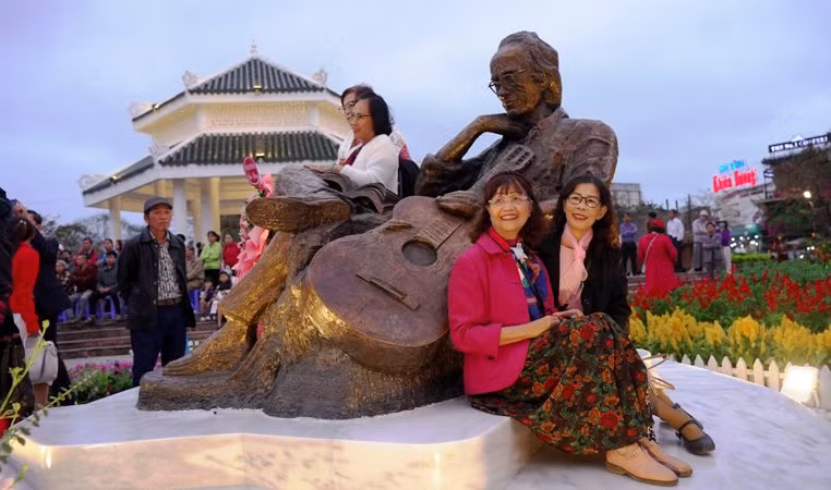 Du khách và người dân bên tượng Trịnh Công Sơn.