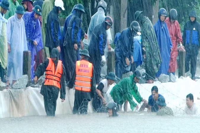 Bộ đội, dân quân tích cực giúp địa phương đắp đê chống sạt lở bờ đê Mai Dương (huyện Quảng Điền).