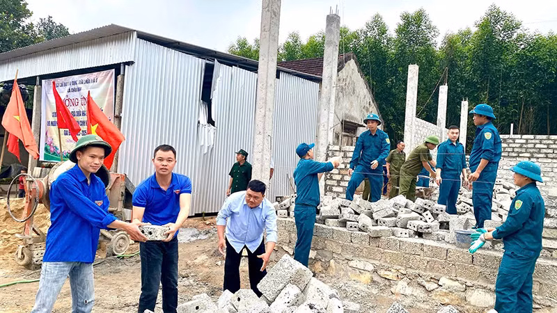 Các đoàn thể và người dân xóm Bảng Cáng, xã Châu Ðình, huyện Quỳ Hợp đến giúp gia đình anh Lương Văn Tùng xây nhà Ðại đoàn kết.