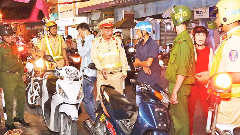 Lực lượng cảnh sát tuyên truyền, nhắc nhở người dân không đậu, đỗ xe dưới lòng đường.