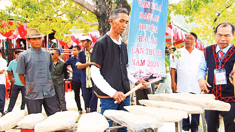 Du khách xem nghệ nhân Mai Háo, huyện Bác Ái biểu diễn độc tấu gõ đàn đá, một loại nhạc cụ độc đáo của dân tộc Raglai ở Ninh Thuận.