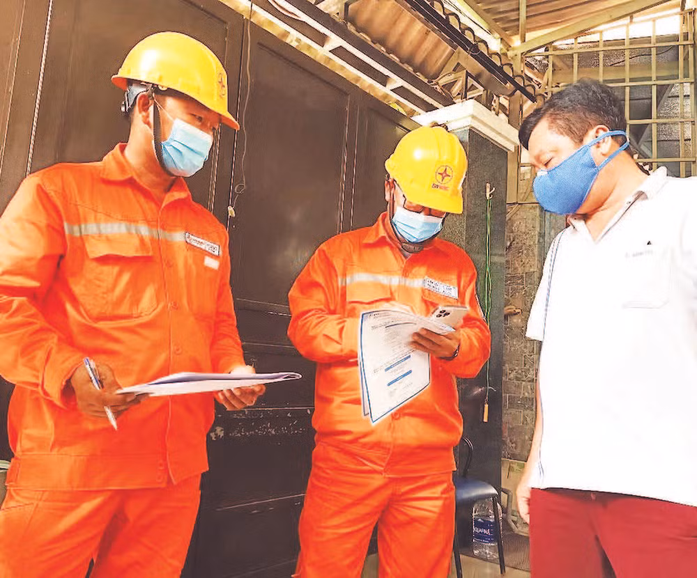 Công nhân Công ty Điện lực thành phố Thủ Đức hướng dẫn người dân sử dụng điện an toàn. 