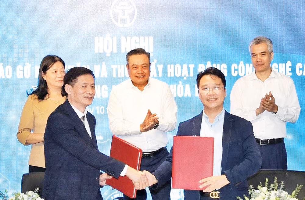 Lãnh đạo Ủy ban nhân dân thành phố Hà Nội chứng kiến ký kết và trao đổi thỏa thuận hợp tác tại hội nghị đối thoại tháo gỡ khó khăn và thúc đẩy hoạt động công nghệ cao tại Khu Công nghệ cao Hòa Lạc. (Ảnh TIẾN THÀNH) 