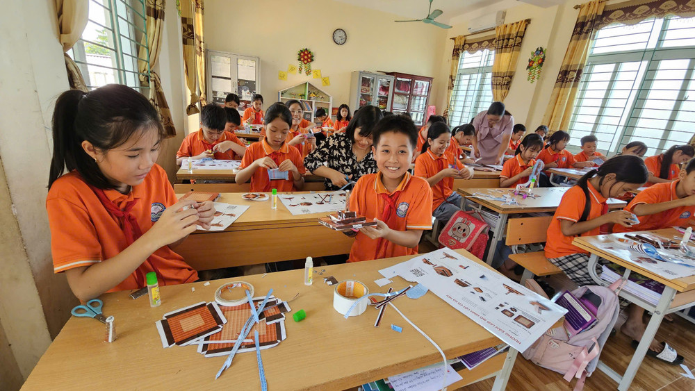 Học sinh Trường tiểu học Đại Đồng, huyện Vĩnh Tường phấn khích với mô hình Cột cờ Hà Nội của Báo Nhân Dân tặng. 