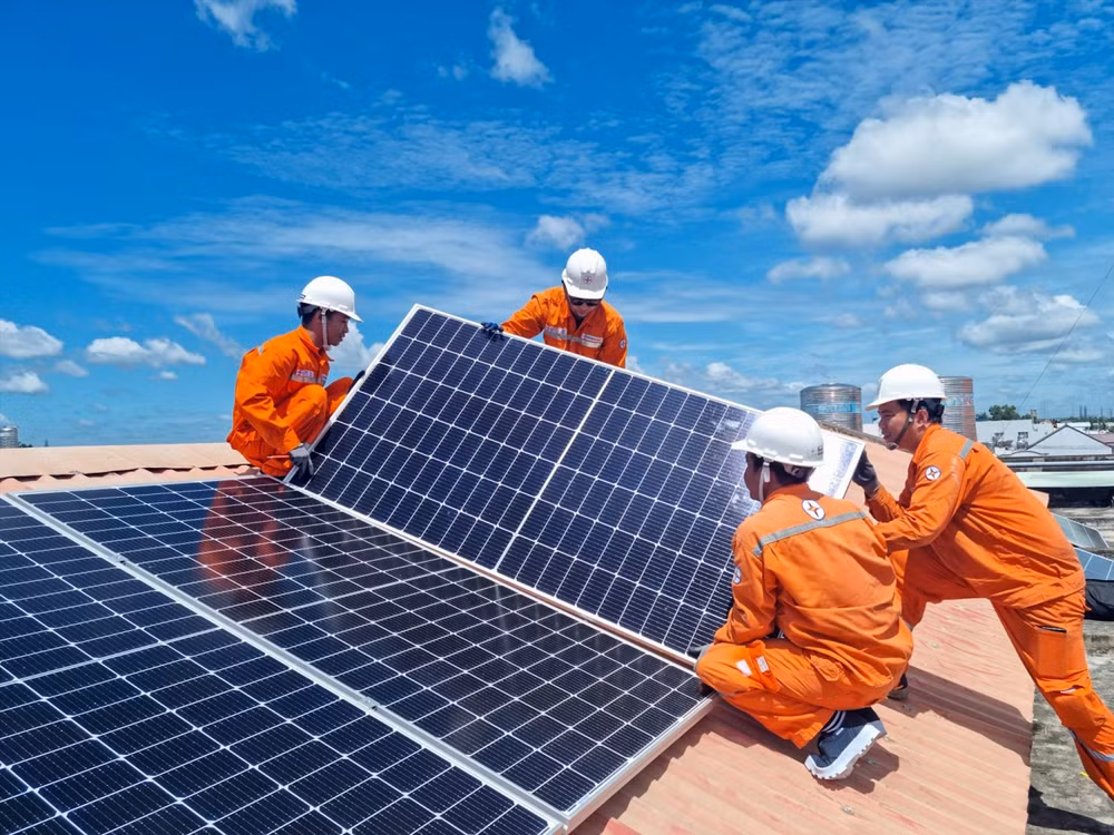 Công nhân Tổng công ty Điện lực Thành phố Hồ Chí Minh lắp đặt hệ thống điện mặt trời trên mái nhà. (Ảnh NAM DƯƠNG) 