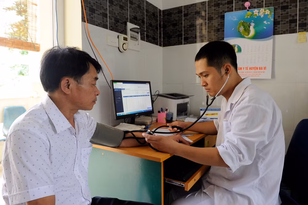 Bác sĩ Trạm y tế xã Ba Trại, huyện Ba Vì (Hà Nội) khám bệnh cho người dân. (Ảnh TUỆ NGHI)