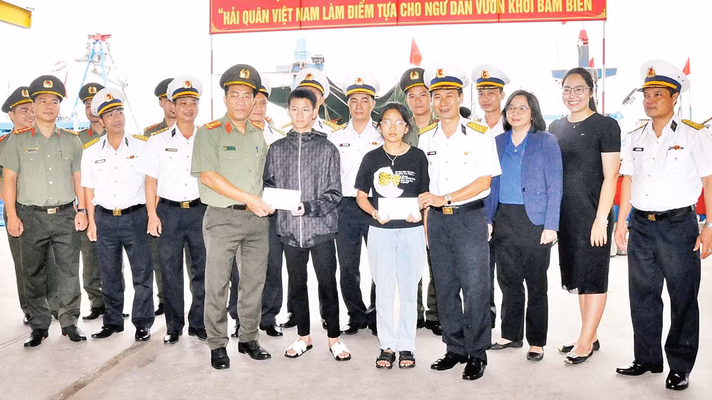 Trao tiền hỗ trợ cho hai trong số 12 cháu là con ngư dân có hoàn cảnh đặc biệt khó khăn được cán bộ, chiến sĩ Vùng 3 Hải quân nhận đỡ đầu. 