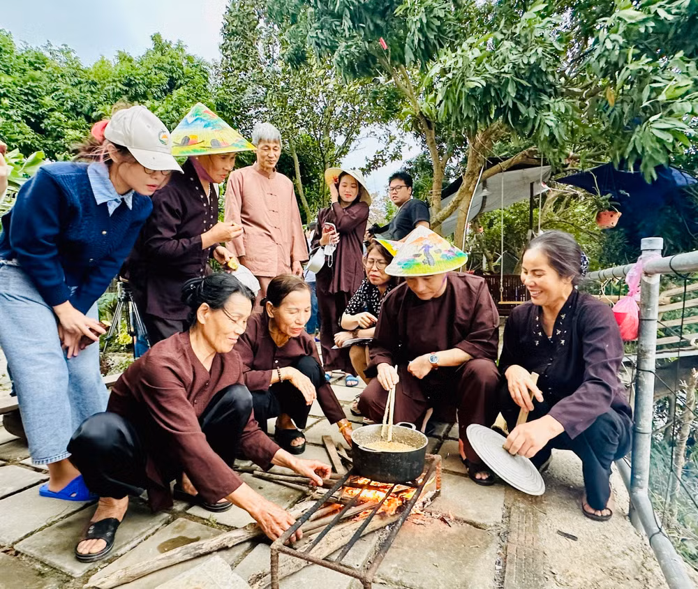 Khách du lịch trải nghiệm nấu bánh đúc khi đến với mô hình du lịch nông nghiệp tại Giang Biên (quận Long Biên, Hà Nội).