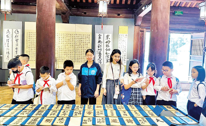 Học sinh Thủ đô tham quan, tìm hiểu các hoạt động văn hóa truyền thống tại di tích Văn Miếu-Quốc Tử Giám. 