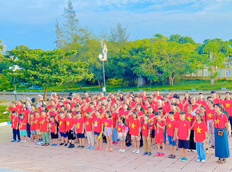 Nhóm đồng hành "Đi để hiểu" cùng cán bộ, chiến sĩ hải quân thực hiện nghi lễ chào cờ trên đảo Cồn Cỏ (Quảng Trị).