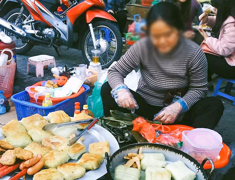 Một hàng đồ ăn trên đường không được che đậy cẩn thận. (Ảnh TUỆ NGHI)