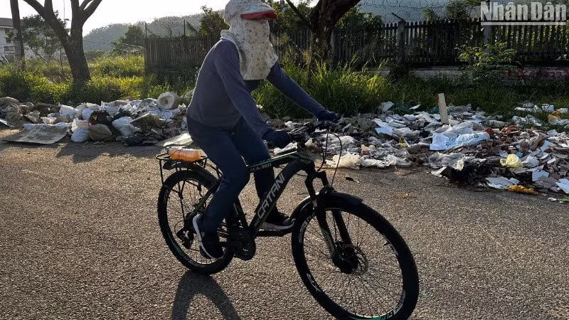 Người dân đi tập thể dục qua đoạn đường đầy rác thải, ảnh chụp chiều ngày 12/5. (Ảnh: ANH ĐÀO)