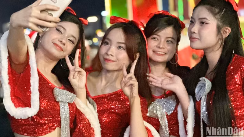 Nhóm bạn trẻ trong trang phục chào đón Noel lưu lại khoảnh khắc đẹp tại sự kiện Thắp sáng cây thông ánh sáng tối ngày 16/12. (Ảnh: ANH ĐÀO)