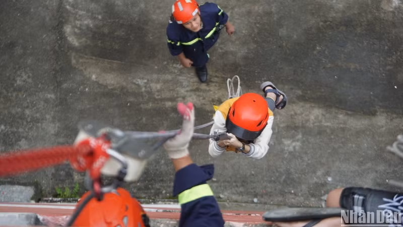 Học sinh Đà Nẵng trải nghiệm thoát hiểm bằng dây. (Ảnh: ANH ĐÀO)