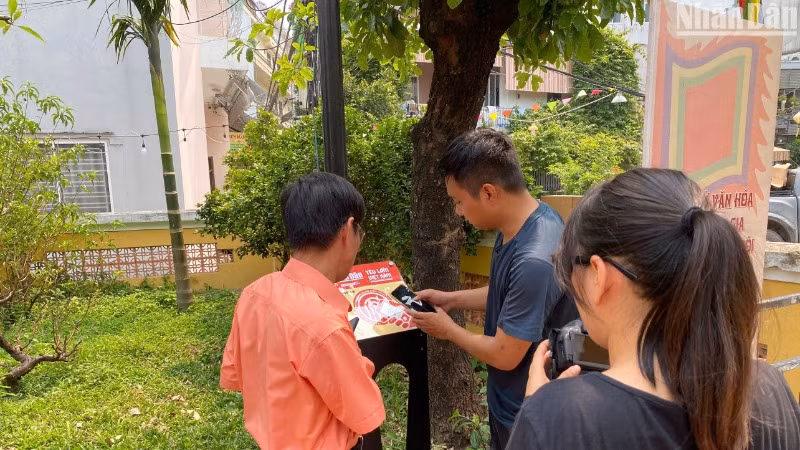 Lắp đặt bảng gắn chip NFC trong Dự án "Yêu lắm Việt Nam" tại Di tích quốc gia Đình làng Hải Châu. (Ảnh: ANH ĐÀO)
