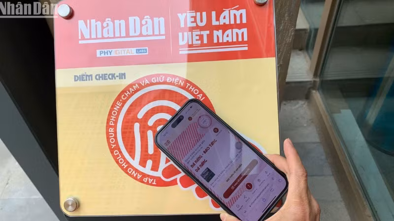 Du khách trải nghiệm check-in tại Bảo tàng Đà Nẵng qua quét bảng gắn chip NFC. (Ảnh: ANH ĐÀO)