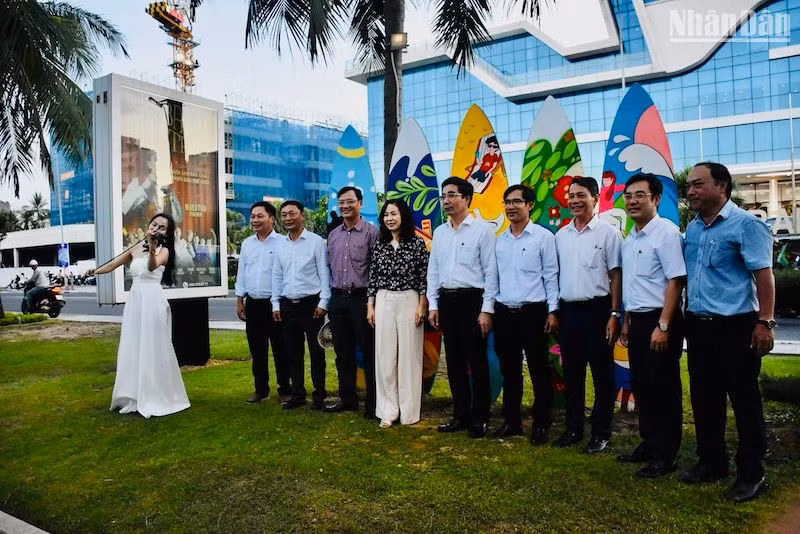 Các đại biểu chụp ảnh lưu niệm với nghệ sĩ biểu diễn âm nhạc trên Đường hoa biển Đà Nẵng. (Ảnh: ANH ĐÀO)