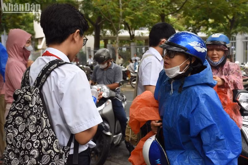 Trời mưa, nhiều thí sinh đội mưa đến điểm thi. (Ảnh: ANH ĐÀO)